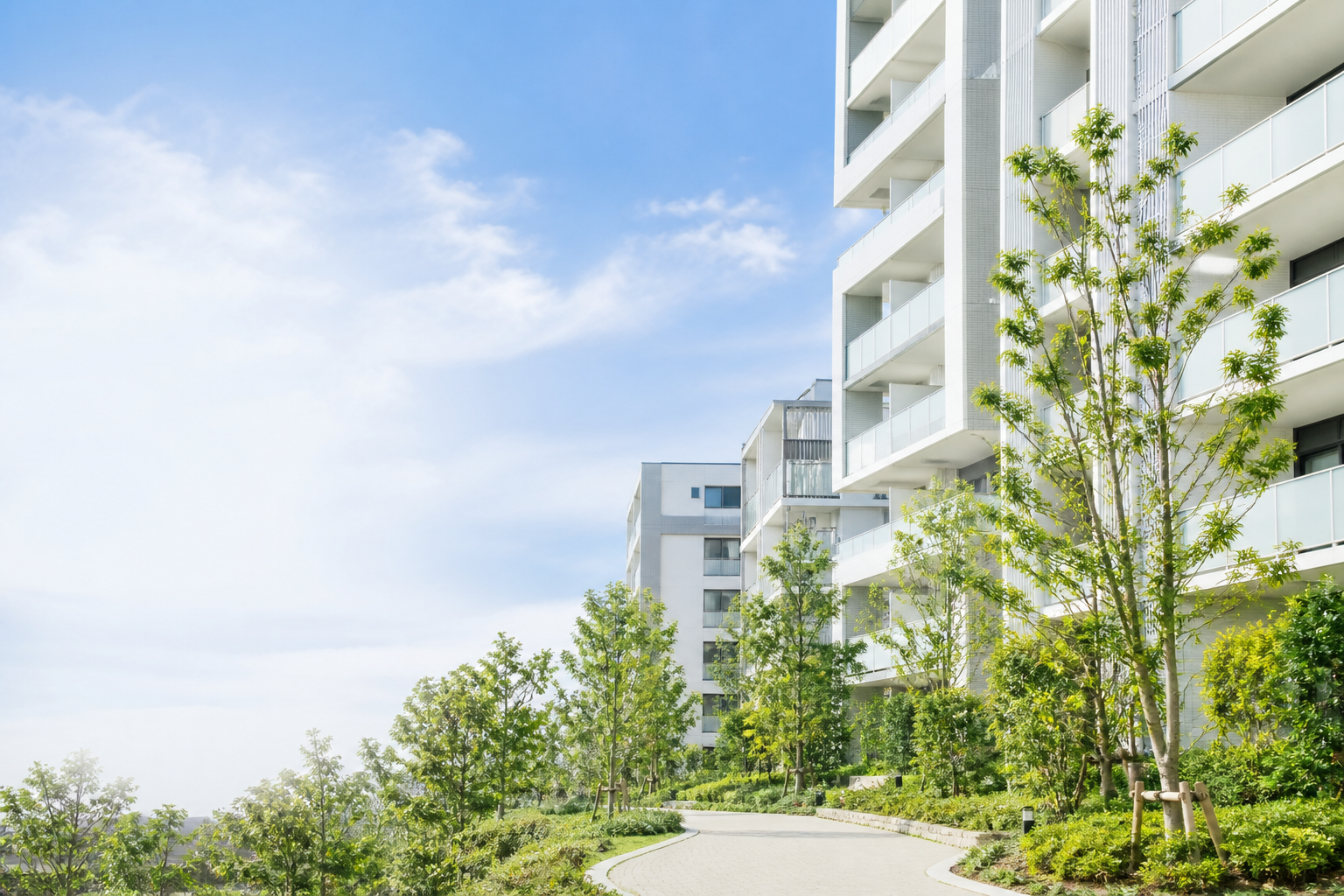 緑に囲まれた明るいマンション外観